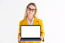 Portrait Of Young Caucasian Blond Woman In Jacket With Laptop On White Background. Beautiful Female Holding Computer With Blank Screen, Looking At The Camera And Smiling
