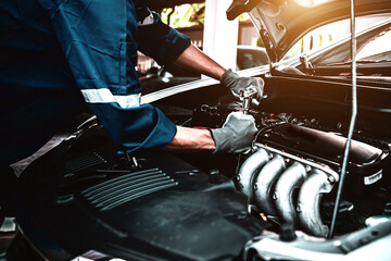 Car care maintenance and servicing, Close-up hand technician auto mechanic using the wrench to repairing change spare part car engine problem and car insurance service support.