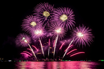 Wall Mural - Amazing beautiful colorful fireworks display on celebration night, showing on the sea beach with multi color of reflection on water	