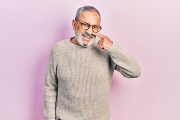 Sticker - Handsome senior man with beard wearing casual sweater and glasses pointing with hand finger to face and nose, smiling cheerful. beauty concept