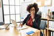 African american woman with afro hair working at the office wearing operator headset asking to be quiet with finger on lips. silence and secret concept.