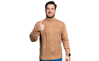 Wall Mural - Young hispanic man wearing casual clothes doing happy thumbs up gesture with hand. approving expression looking at the camera showing success.