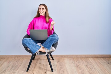 Sticker - Young hispanic girl working using computer laptop very happy and excited doing winner gesture with arms raised, smiling and screaming for success. celebration concept.