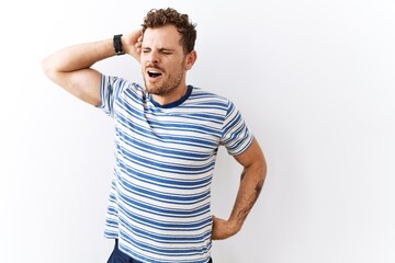 Poster - Handsome young man standing over isolated background stretching back, tired and relaxed, sleepy and yawning for early morning