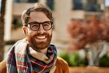 Wall Mural - Young caucasian man with beard wearing glasses outdoors on a sunny day