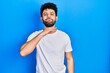 © Krakenimages.com - Young arab man with beard wearing casual white t shirt cutting throat with hand as knife, threaten aggression with furious violence