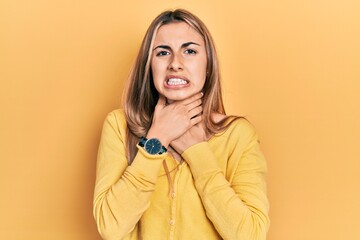 Poster - Beautiful hispanic woman wearing casual yellow sweater shouting suffocate because painful strangle. health problem. asphyxiate and suicide concept.