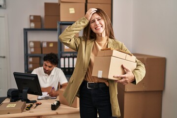 Canvas Print - Young two people working at small business ecommerce stressed and frustrated with hand on head, surprised and angry face