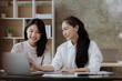 © kamiphotos - Two beautiful Asian women are meeting together in a company meeting room, meeting to discuss plans to develop the business to grow and follow the business plan. Business meeting idea.