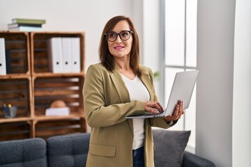 Canvas Print - Middle age woman psychologist using laptop at psychology center