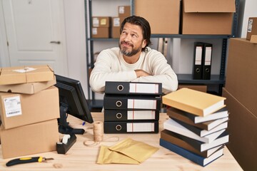 Sticker - Handsome middle age man working at small business ecommerce smiling looking to the side and staring away thinking.