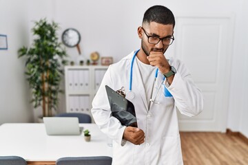 Sticker - Young indian man wearing doctor uniform and stethoscope feeling unwell and coughing as symptom for cold or bronchitis. health care concept.