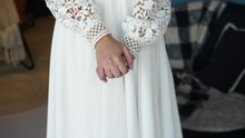 The Girl In The Dress Holds Both Hands Next To Each Other. Hand Hugs On A Boho Style Dress Background.