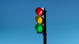 Fototapeta Uliczki - traffic light with red, yellow and green colors on isolated on blue sky background. Mock-up or source. 3d render