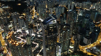 Sticker - Aerial view of dense skyscrapers with illuminated lights at night in Hong Kong