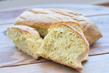 Canvas Print - wheat bread, traditional village bread, kneaded by hand, on a wooden table