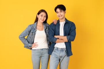 Wall Mural - Two Young good looking asian couple using isolated on yellow background