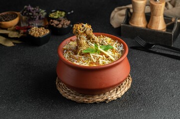 Canvas Print - Closeup of a Chicken biryani in a pot on the table