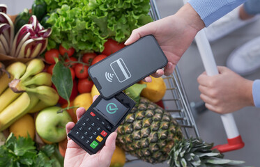 Woman paying using her smartphone at the supermarket