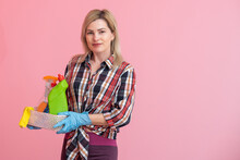 Bottles With Household Chemicals In A Wicker Basket In The Hands Of A Caucasian Woman. Pink Background. Place For Text.