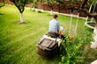 Portrait of happy worker using lawn tractor for cutting grass