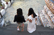 Close up photo of friends descending the stairs in an ancient Buddhist temple