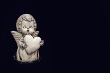 Sympathy Card With Angel Holding A Heart Isolated On Black Background With Copy Space