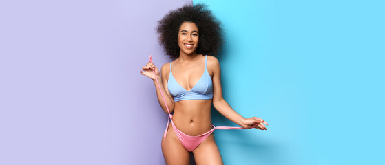 Poster - Beautiful African-American woman in bikini on color background