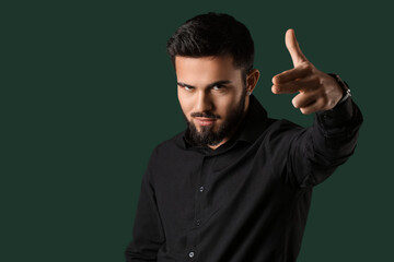 Poster - Bearded man pointing fingers gun gesture on color background