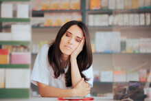 Tired Pharmacist Sitting Behind The Counter In A Drugstore