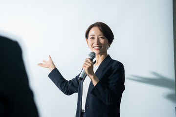 Wall Mural - マイクを持ちプレゼンする日本人女性