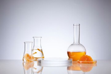 Wall Mural - Front view of orange decorated with glassware and transparent podium in white background	