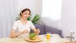 © snowing12 - Lifestyle in living room concept, Young Asian woman mixing vegetable salad in bowl for breakfast
