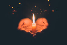 Woman Hands Praying In The Light Candles