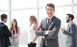 © ASDF - smiling young businessman standing in office.