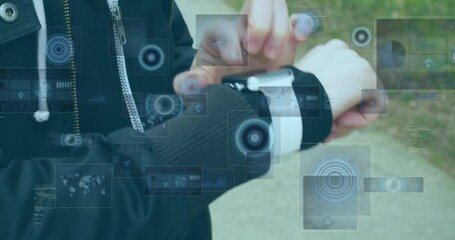 Canvas Print - Animation of data processing on screens over caucasian man checking smartwatch