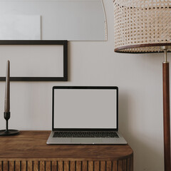 Wall Mural - Laptop computer with blank screen on table with candles, floor lamp. Aesthetic boho styled home interior design template with mockup copy space. Online store, blog, social media, shop branding