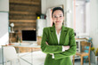 © Westend61 - Smiling businesswoman with arms crossed standing in office