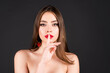 Womens secrets. Woman showing secret sign. Female with finger in mouth. Closeup portrait of young woman is showing a sign of silence with shhh. Beauty portrait of beautiful female model.