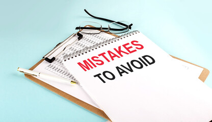 Poster - MISTAKES TO AVOID text on notepad on clipboard with chart on blue background, concept closeup. Business and finance concept