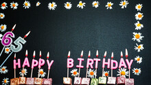 Happy Birthday Background With Number   65. Copy Space. Pink Happy Birthday Candles On A Black Background. Happy Birthday Flower Frame