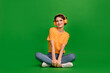 canvas print picture - Full length photo of charming peaceful girl sit floor enjoy new playlist isolated on green color background