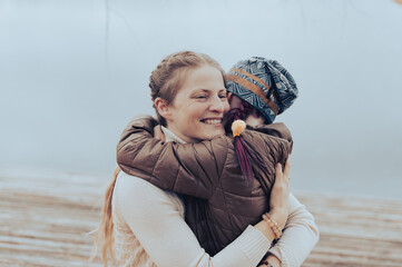 Loving mom and her little daughter embrace each other in a moment of love emotion