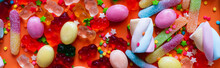 Top View Of Assorted Jelly Sweets And Candies On Orange Background, Banner.