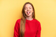 Young caucasian woman isolated on yellow background funny and friendly sticking out tongue.