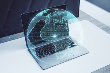 Poster - Close up of workplace with laptop and creative glowing polygonal grid planet on blurry background. Globe, international map, communication, network earth and technology concept. Double exposure.