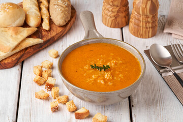 Composition with bowl with delicious carrot soup and croutons  on wooden table.      