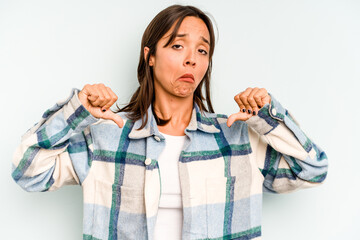 Wall Mural - Young hispanic woman isolated on blue background shocked covering mouth with hands.