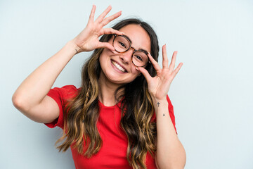 Wall Mural - Young caucasian woman isolated on blue background showing okay sign over eyes