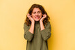 © Asier - Young caucasian woman isolated on yellow background covering ears with hands.